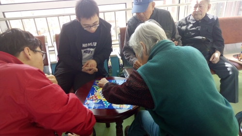 志愿者在陪老人下跳棋